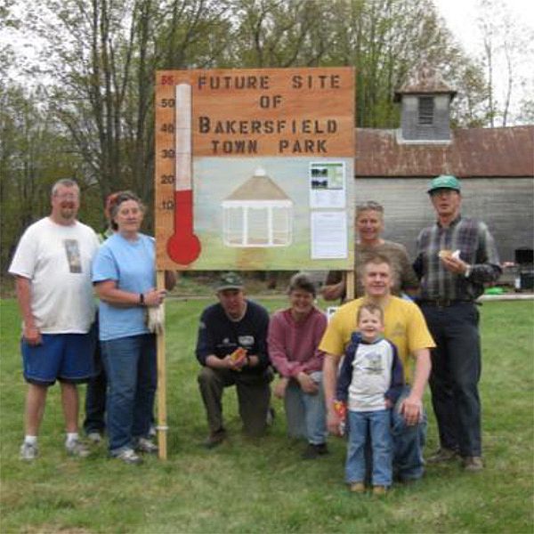 Photo of people posing around a sign reading: Future Site of Bakersfield Town Park.