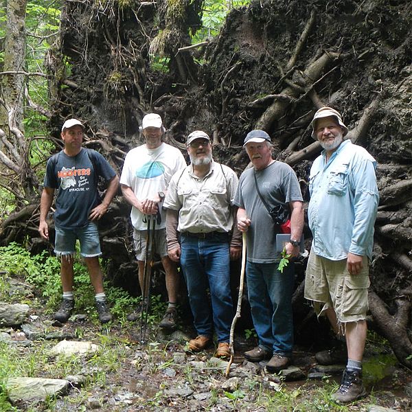 Photo of Keeping Track participants in front of an uprooted tree.